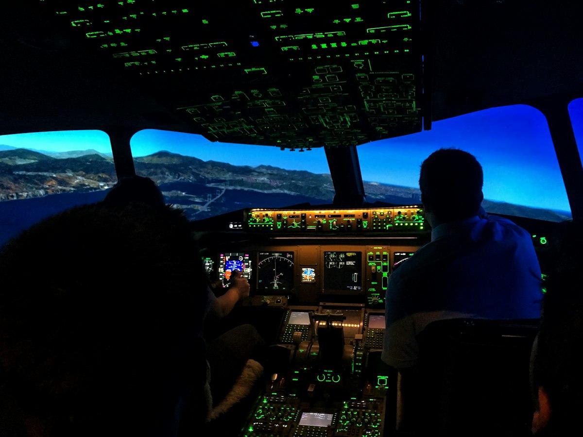 Pilots seated in a flight simulator cockpit